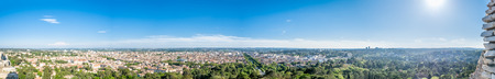 Panorama of cityscape view of Nimes, view from ancient Roman tower, under cloudy blue sky in France