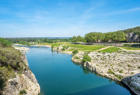 Gardon river beneath Pont du Gard, ancient Roman aqueduct, under blue sky in Nimes, Franceの写真素材