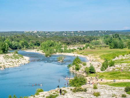 Gardon river beneath Pont du Gard, ancient Roman aqueduct, under blue sky in Nimes, Franceの写真素材