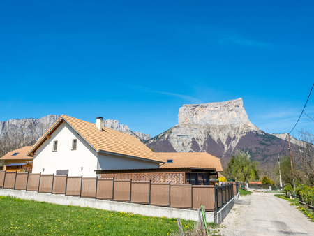 Buildings of house in Chichilianne town, small town in valley, countryside of France, under clear blue sky in spring season, with mount Aiguille in backgroundのeditorial素材