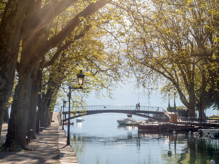 Lovers' bridge, landmark of Annecy, cross small canal to the lake in Annecy, France, under clear blue sky in outdoor parkの写真素材