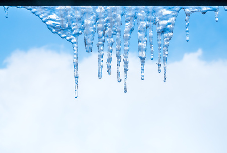 Condensated ice at window rim with cloudy blue sky in backgroundの写真素材