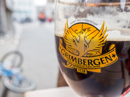 CHAMONIX-MONT-BLANC, FRANCE - APRIL 15 : Grimbergen draught dark beer in unique glass on outdoor table in Poco Loco burger shop in Chamonix Mont Blanc town, France, on April 15, 2017.のeditorial素材