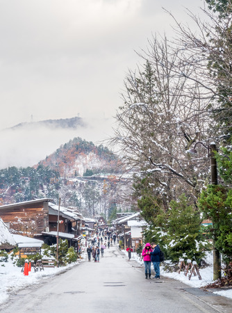 GIFU, JAPAN - NOVEMBER 25 : Walking street with tourists in Shirakawa village in early winter season with snow under cloudy sky in Gifu, Japan, on November 25 ,2017.のeditorial素材
