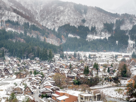 Viewpoint from hill near Shirakawa village, with mountains in background, in early winter season with snow coverの写真素材