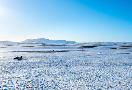 Snow field with mountains under clear blue sky in rural area of Icelandの写真素材