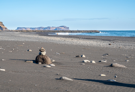 Reynisfjara black sand beach is landmark of Vik town in Iceland, fine black sand with small stones on beachの写真素材
