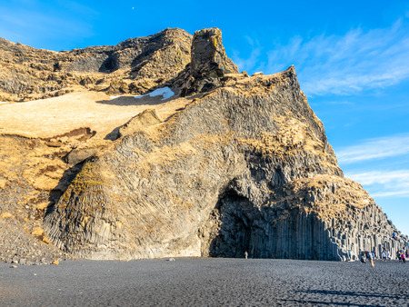 Reynisfjara black sand beach is landmark of Vik town in Iceland, surrounded with basalt mountains, under blue sky in winter seasonの写真素材
