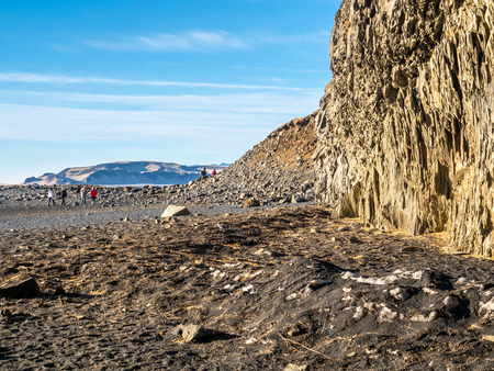 Reynisfjara black sand beach is landmark of Vik town in Iceland, surrounded with basalt mountains, under blue sky in winter seasonの写真素材