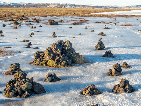 LaufskÃ¡lavarÃ°a, lava ridge between river, surrounded with stone cairns, just side of golden ring road in Iceland. In winter season, field becomes ice and snow.の写真素材