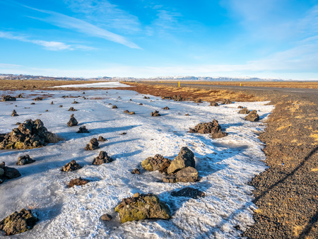 LaufskÃ¡lavarÃ°a, lava ridge between river, surrounded with stone cairns, just side of golden ring road in Iceland. In winter season, field becomes ice and snow.の写真素材
