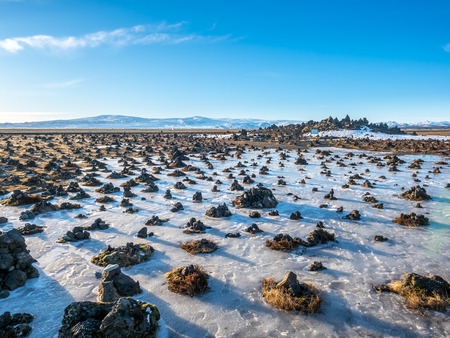 LaufskÃ¡lavarÃ°a, lava ridge between river, surrounded with stone cairns, just side of golden ring road in Iceland. In winter season, field becomes ice and snow.の写真素材