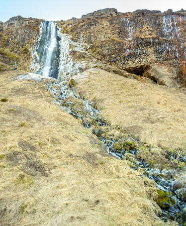 Large waterfall near Seljalandsfoss waterfall with large snow on rock in south side of Iceland, in winter seasonの写真素材