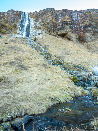 Large waterfall near Seljalandsfoss waterfall with large snow on rock in south side of Iceland, in winter seasonの写真素材