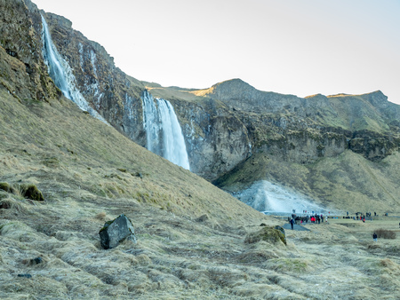 Large waterfall near Seljalandsfoss waterfall with large snow on rock in south side of Iceland, in winter seasonの写真素材