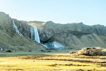 Large waterfall near Seljalandsfoss waterfall with large snow on rock in south side of Iceland, in winter seasonの写真素材