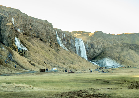 Large waterfall near Seljalandsfoss waterfall with large snow on rock in south side of Iceland, in winter seasonの写真素材