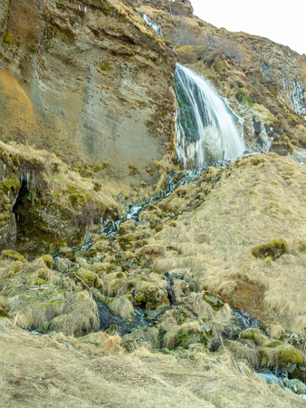 Large waterfall near Seljalandsfoss waterfall with large snow on rock in south side of Iceland, in winter seasonの写真素材