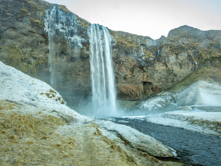 Siljalandsfoss waterfall, one of landmark in Iceland, large waterfall with natural cliff in winter season with snow and ice aroundの写真素材