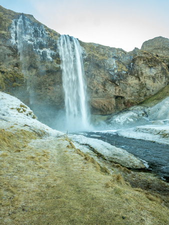 Siljalandsfoss waterfall, one of landmark in Iceland, large waterfall with natural cliff in winter season with snow and ice aroundの写真素材