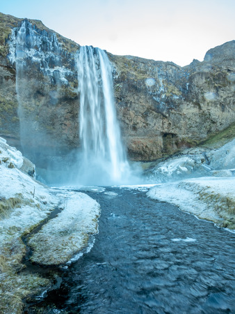 Siljalandsfoss waterfall, one of landmark in Iceland, large waterfall with natural cliff in winter season with snow and ice aroundの写真素材