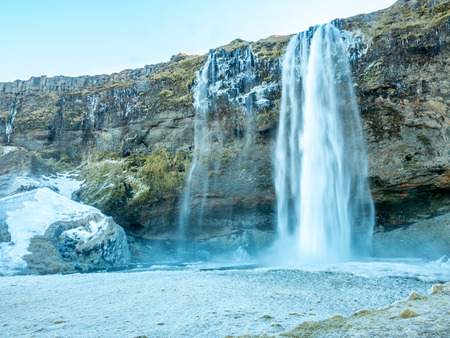 Siljalandsfoss waterfall, one of landmark in Iceland, large waterfall with natural cliff in winter season with snow and ice aroundの写真素材