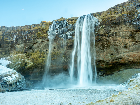 Siljalandsfoss waterfall, one of landmark in Iceland, large waterfall with natural cliff in winter season with snow and ice aroundの写真素材