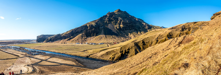 Mountains, hills, meadow and field near Skogafoss waterfall in winter season in Icelandの写真素材