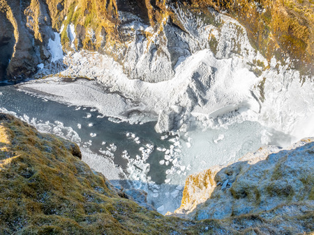 Top view of Skogafoss waterfall with snow and ice in winter season in Icelandの写真素材