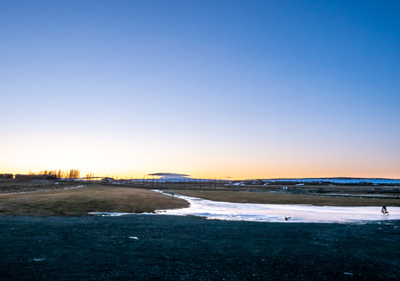 Mountain, field in twilight evening sky with full moon night light in winter season in Icelandの写真素材