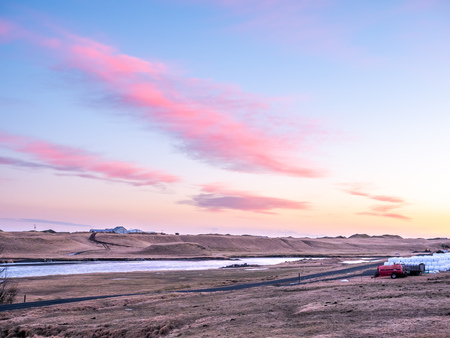 Natural view of mountain and field in outdoor farm under twilight evening sky in Iceland during winter seasonの写真素材
