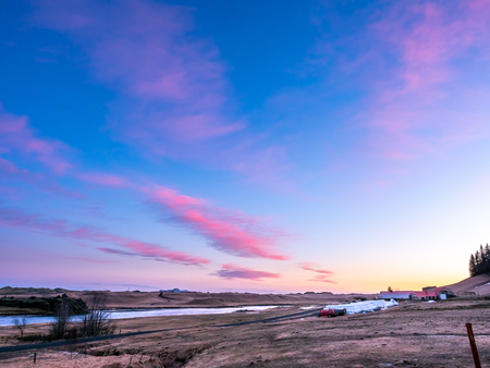 Natural view of mountain and field in outdoor farm under twilight evening sky in Iceland during winter seasonの写真素材