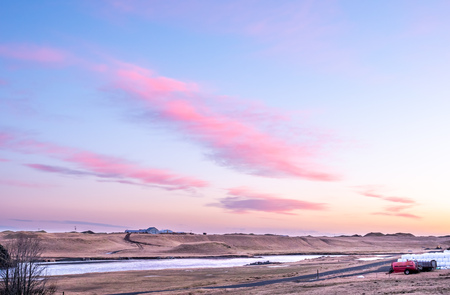 Natural view of mountain and field in outdoor farm under twilight evening sky in Iceland during winter seasonの写真素材