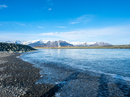 Black sand diamond beach with wave and snow mountains in winter season in Icelandの写真素材