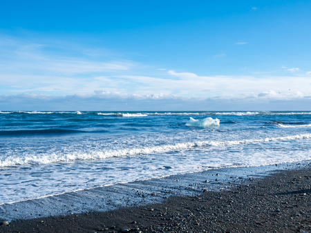 Black sand diamond beach with wave and snow mountains in winter season in Icelandの写真素材