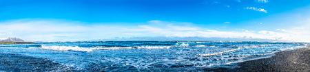 Panorama view of black sand diamond beach with wave and snow mountains in winter season in Icelandの写真素材