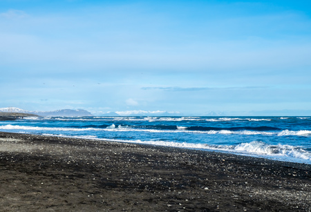Black sand diamond beach with wave and snow mountains in winter season in Icelandの写真素材