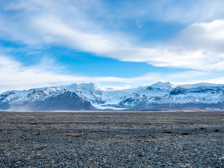 Viewpoint to Hvannadalshnukur peak, with wide plain of black volcanic sand marbled with creeks of run-off from the Skeioararjokull glacierの写真素材