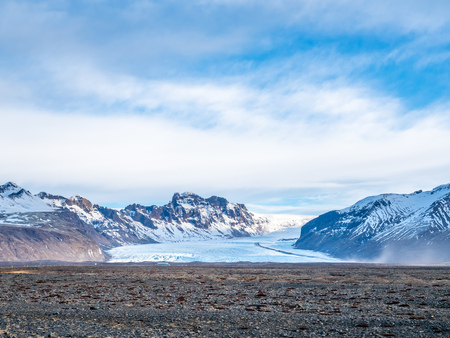 Viewpoint to Hvannadalshnukur peak, with wide plain of black volcanic sand marbled with creeks of run-off from the Skeioararjokull glacierの写真素材