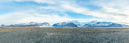 Viewpoint to Hvannadalshnukur peak, with wide plain of black volcanic sand marbled with creeks of run-off from the Skeioararjokull glacierの写真素材