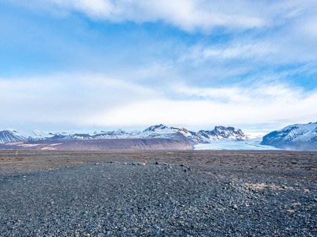 Viewpoint to Hvannadalshnukur peak, with wide plain of black volcanic sand marbled with creeks of run-off from the Skeioararjokull glacierの写真素材