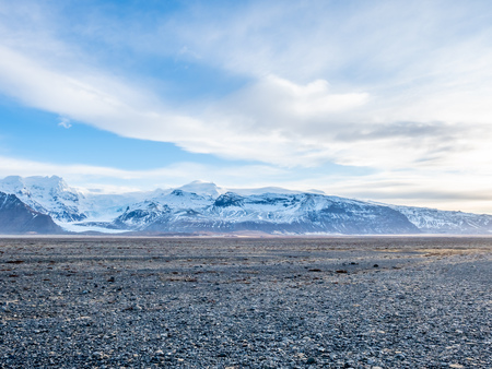 Viewpoint to Hvannadalshnukur peak, with wide plain of black volcanic sand marbled with creeks of run-off from the Skeioararjokull glacierの写真素材