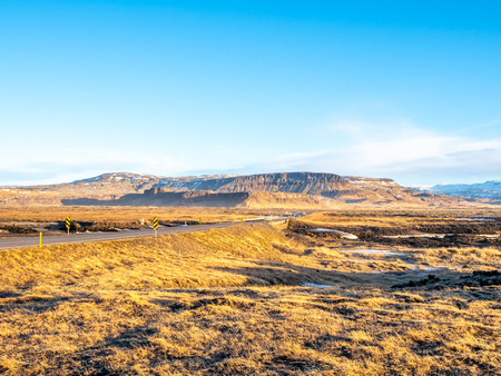 Natural scene with morning mist, field, mountains and cloudy blue sky in rural area in Icelandの写真素材