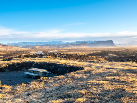 Natural scene with morning mist, field, mountains and cloudy blue sky in rural area in Icelandの写真素材