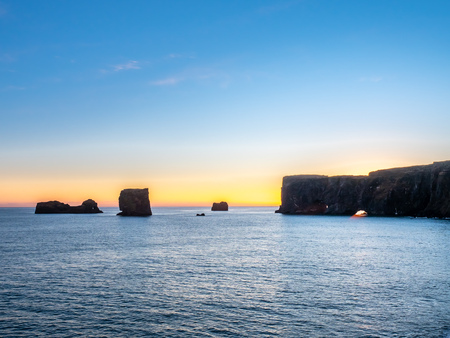 Dyrholaey arch, mean 'the hill island with the door hole', amazing geology viewpoint near Vik town at south of Iceland, during twilight evening sky along coastlineの写真素材