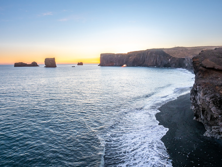 Dyrholaey arch, mean 'the hill island with the door hole', amazing geology viewpoint near Vik town at south of Iceland, during twilight evening sky along coastlineの写真素材
