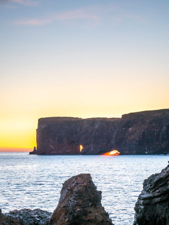 Dyrholaey arch, mean 'the hill island with the door hole', amazing geology viewpoint near Vik town at south of Iceland, during twilight evening sky along coastlineの写真素材