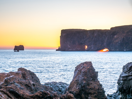Dyrholaey arch, mean 'the hill island with the door hole', amazing geology viewpoint near Vik town at south of Iceland, during twilight evening sky along coastlineの写真素材