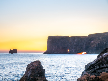 Dyrholaey arch, mean 'the hill island with the door hole', amazing geology viewpoint near Vik town at south of Iceland, during twilight evening sky along coastlineの写真素材