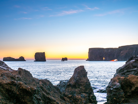 Dyrholaey arch, mean 'the hill island with the door hole', amazing geology viewpoint near Vik town at south of Iceland, during twilight evening sky along coastlineの写真素材